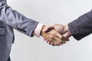 Business handshake on grey background
